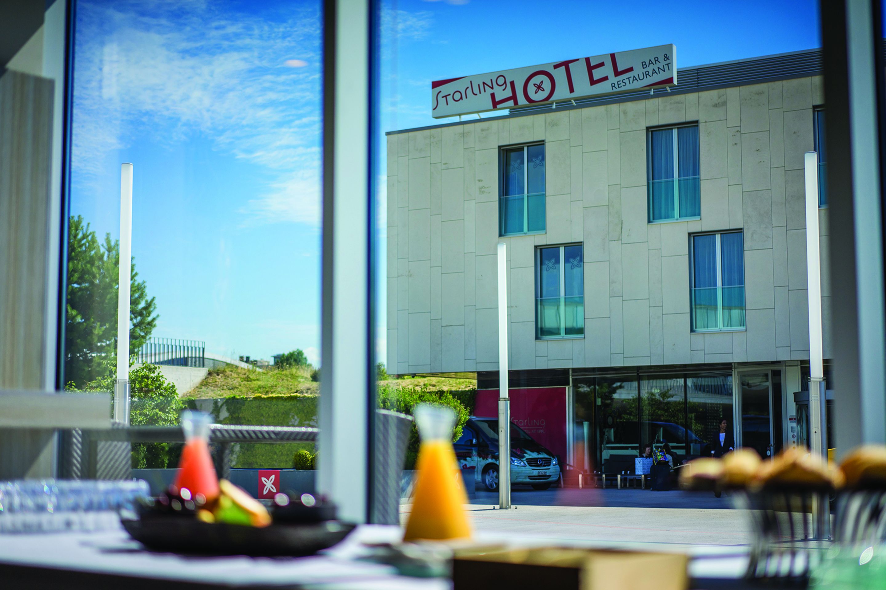A hotel with a sign reading "Starling Hotel Bar & Restaurant" and a view of the street outside.
