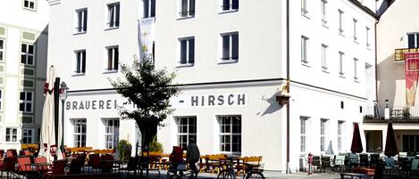 A building with multiple windows and a sign that reads "BRAUEREI HIRSCH".
