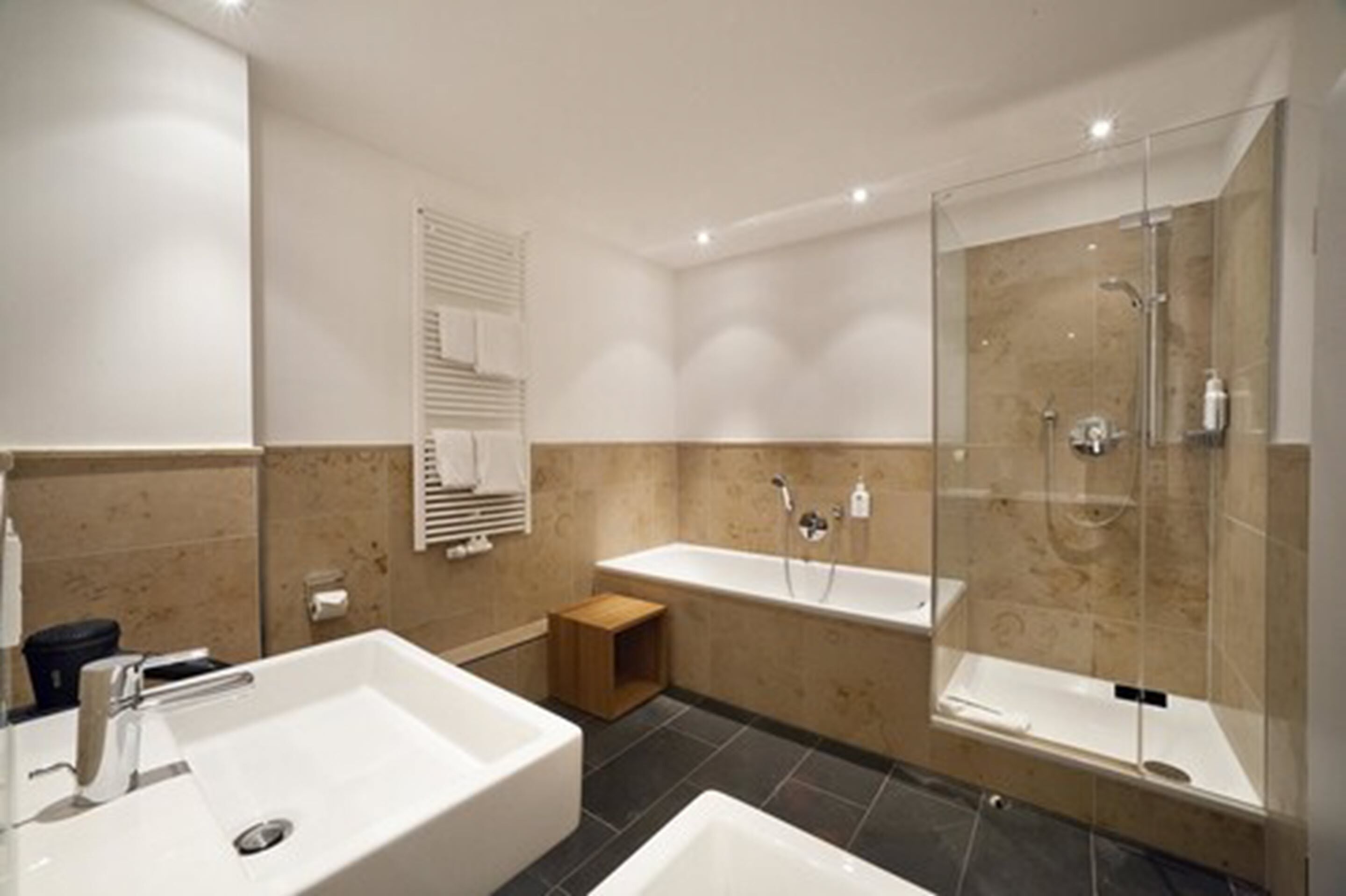 A modern bathroom with a large bathtub, a separate shower area, and a vanity with a sink.