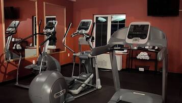 Gimnasio con cintas de correr, elíptica y bicicleta estática.