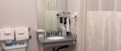 Un baño con inodoro, lavabo y cortina de ducha.
