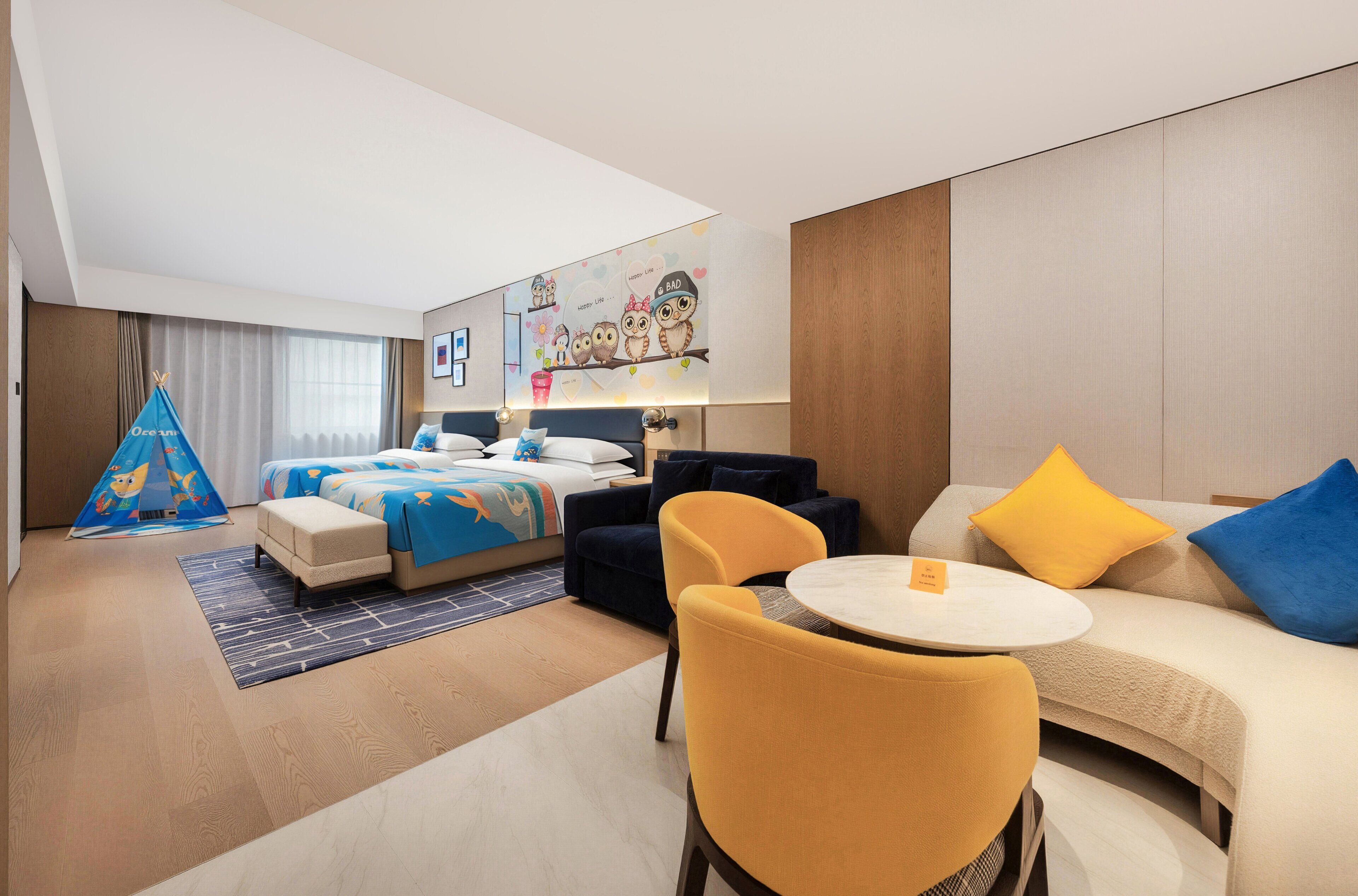 A hotel room with a bed, a sofa, a small table, and a chair.