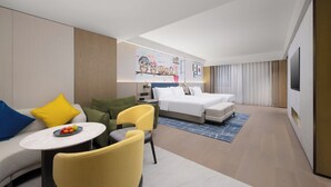 Une chambre d’hôtel avec un lit, un canapé, une table à manger et une chaise.
