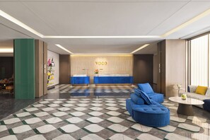A modern lobby with a checkered floor, reception desk, and seating area. - voco Suzhou Guanqian Street by IHG (Suzhou)