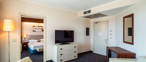 Una habitación de hotel con cama, televisión, escritorio y silla.