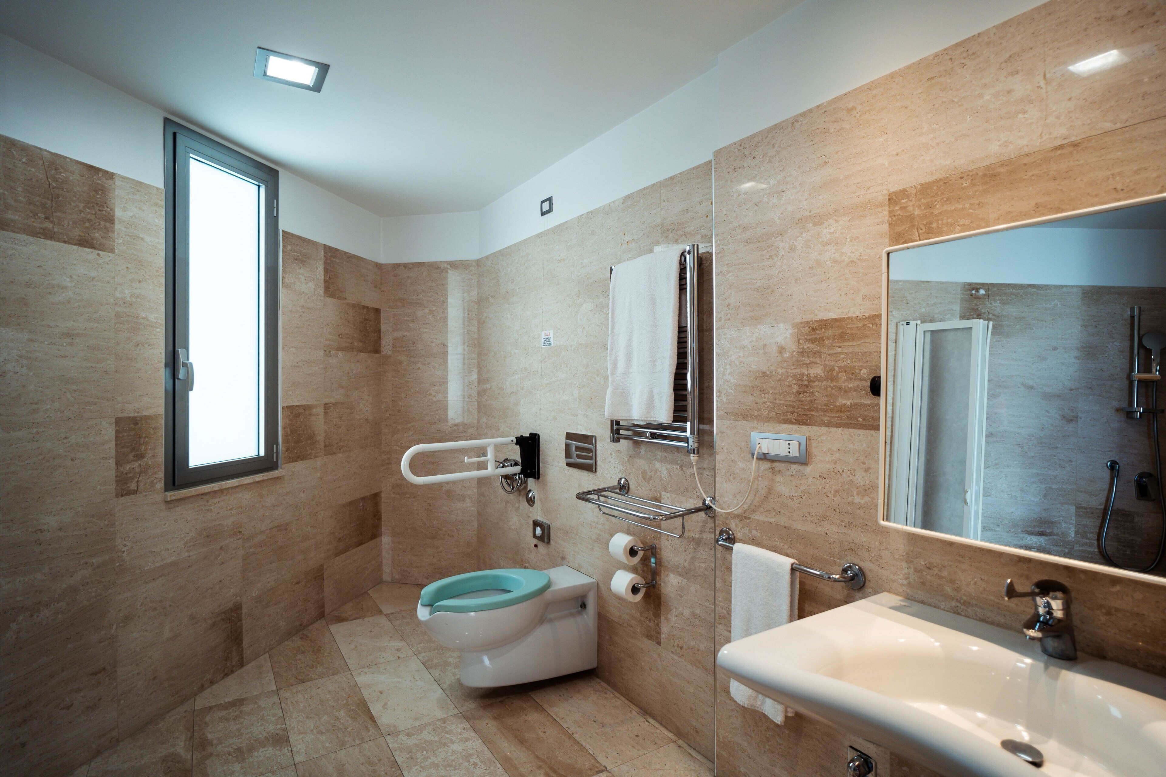 A modern bathroom with a toilet, sink, and shower.