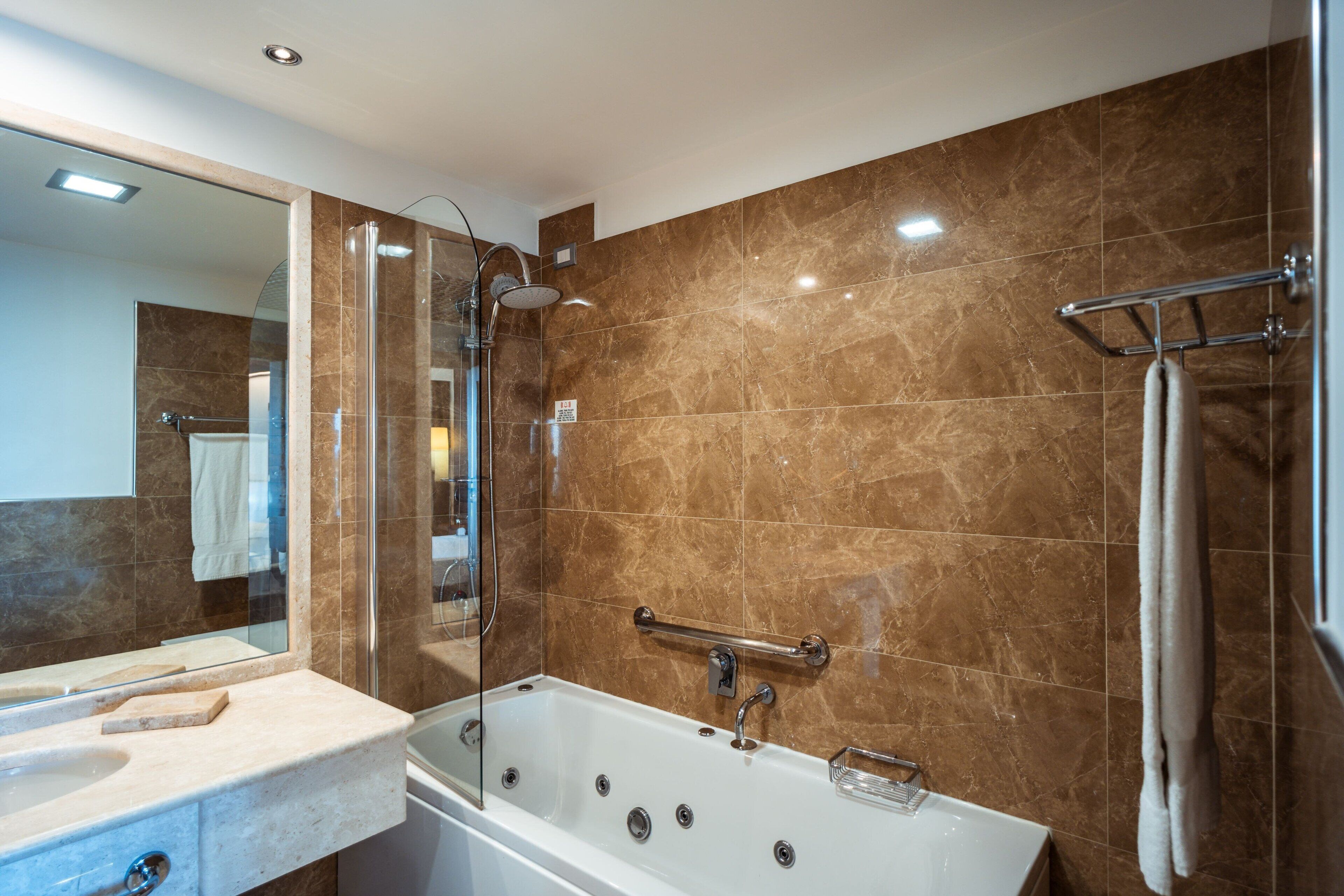 Un baño moderno con bañera, cabina de ducha de vidrio y tocador con lavabo.