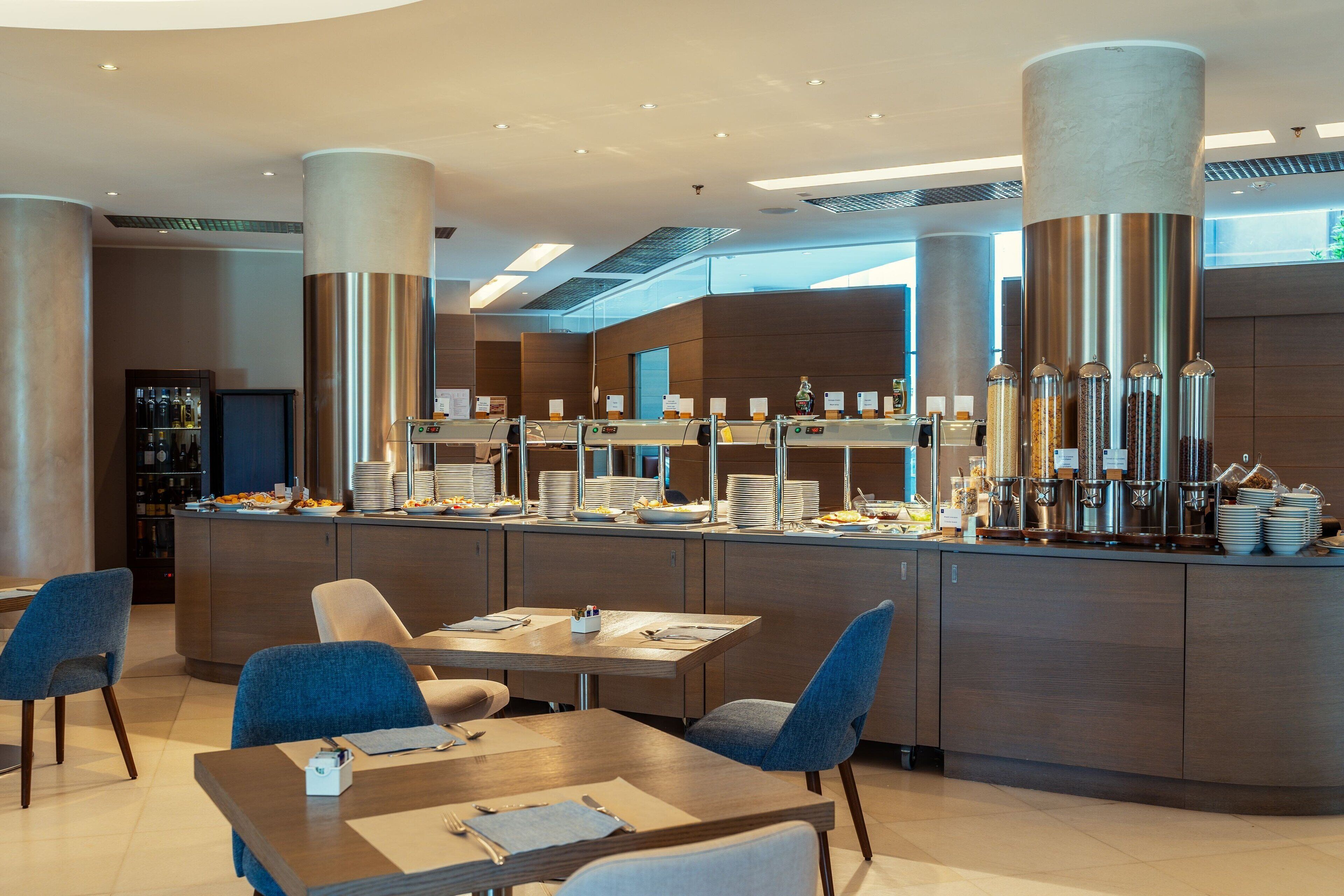 Una moderna colazione a buffet con posti a sedere e una postazione caffè.