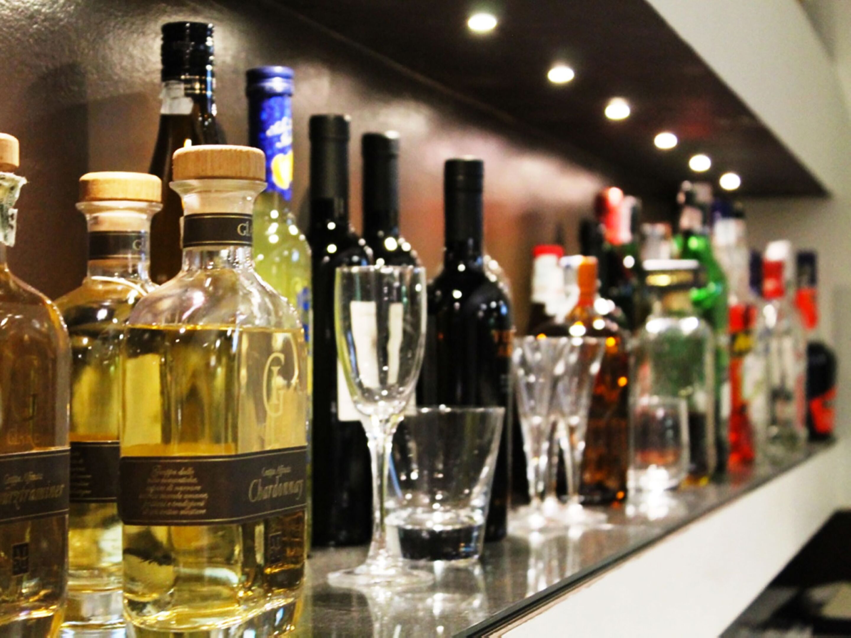 Eine Bar mit verschiedenen Spirituosenflaschen und Gläsern.