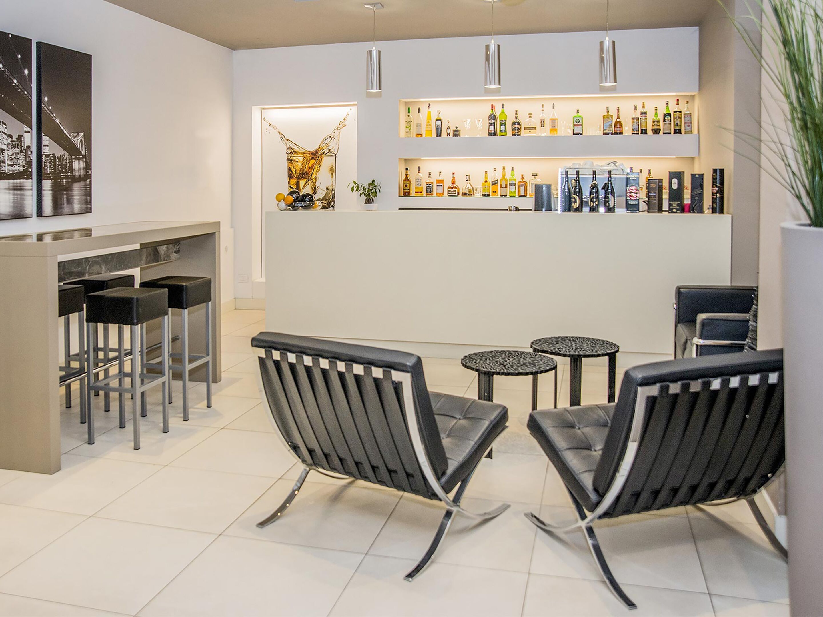 A modern bar area with a bar counter, stools, and seating.