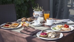 A breakfast table with various food items, a glass of orange juice, and a cup of coffee.