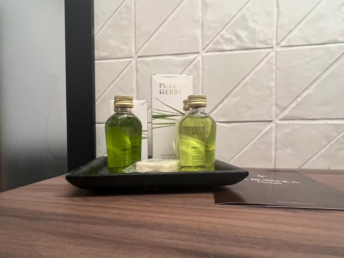A tray with two bottles of Pure Herbs shaving gel and a bar of soap on a wooden surface.