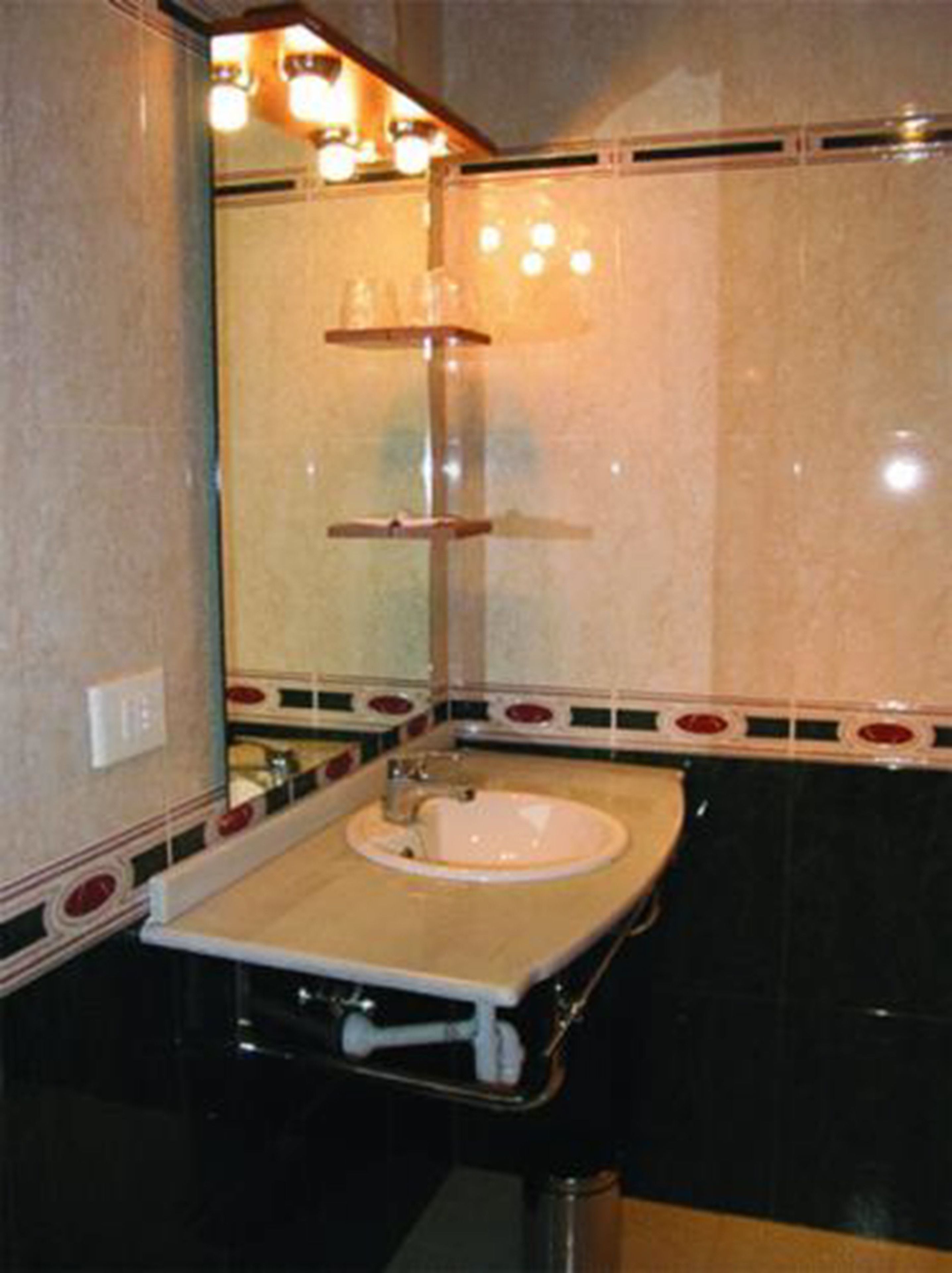 A bathroom with a sink, mirror, and shelves.
