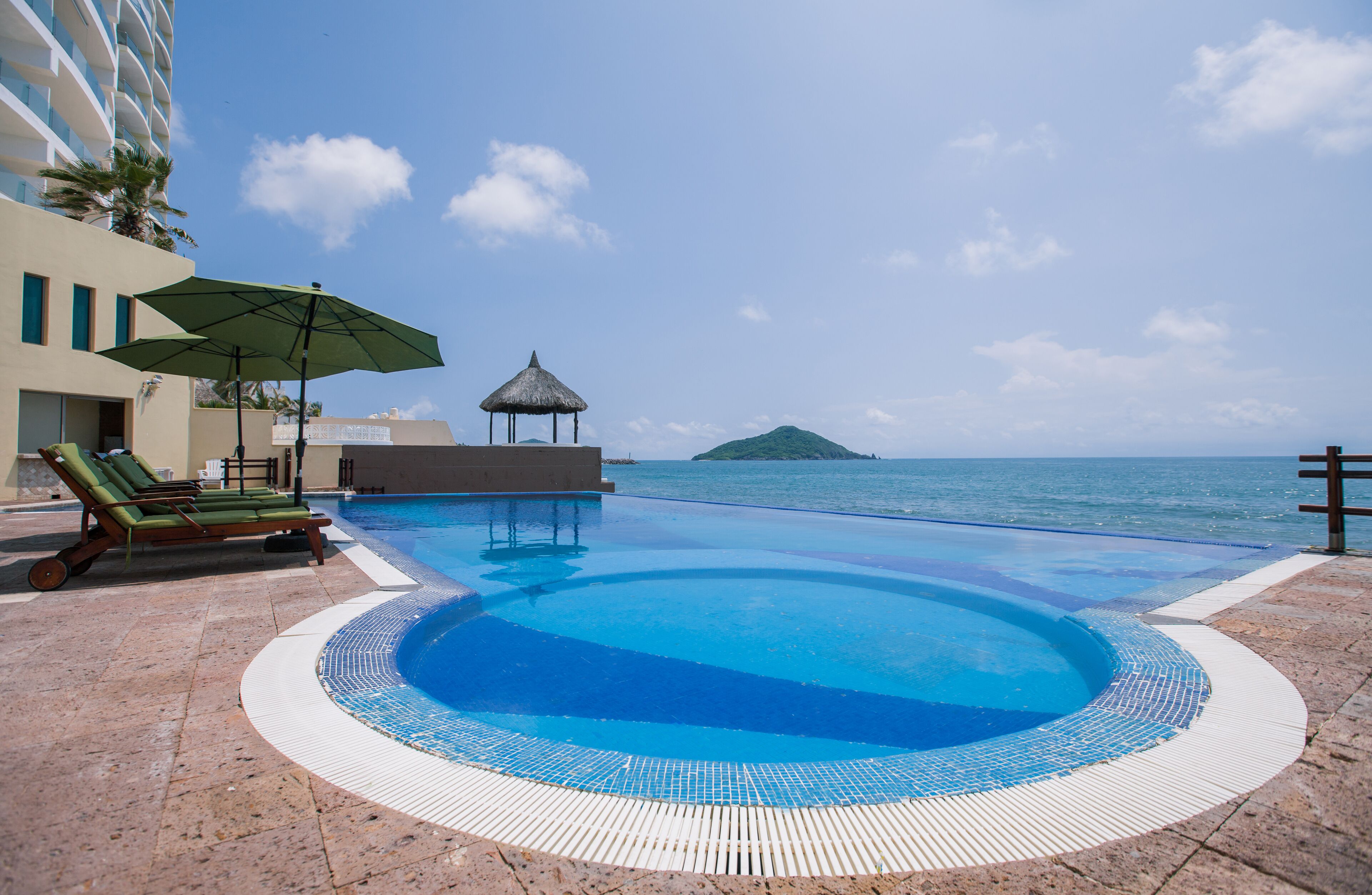 Alberca techada, alberca al aire libre y camastros