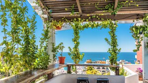 A balcony with a view of the sea, wooden railings, and two black stools. - Hotel Amaca Puerto Vallarta - Adults Only (Puerto Vallarta)