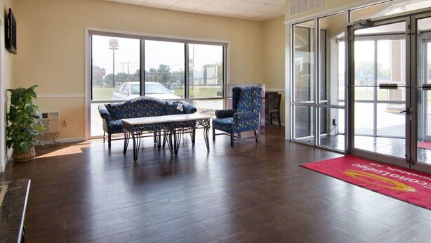 A spacious lobby with a large window, a reception desk, and a blue patterned sofa. - Econo Lodge Pine Bluff (Pine Bluff)