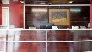 A reception desk with a framed artwork above it, a Dell computer, and a printer. - Econo Lodge Pine Bluff (Pine Bluff)