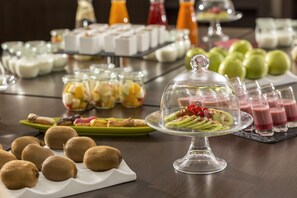 A buffet with various food items including fruits, desserts, and beverages.