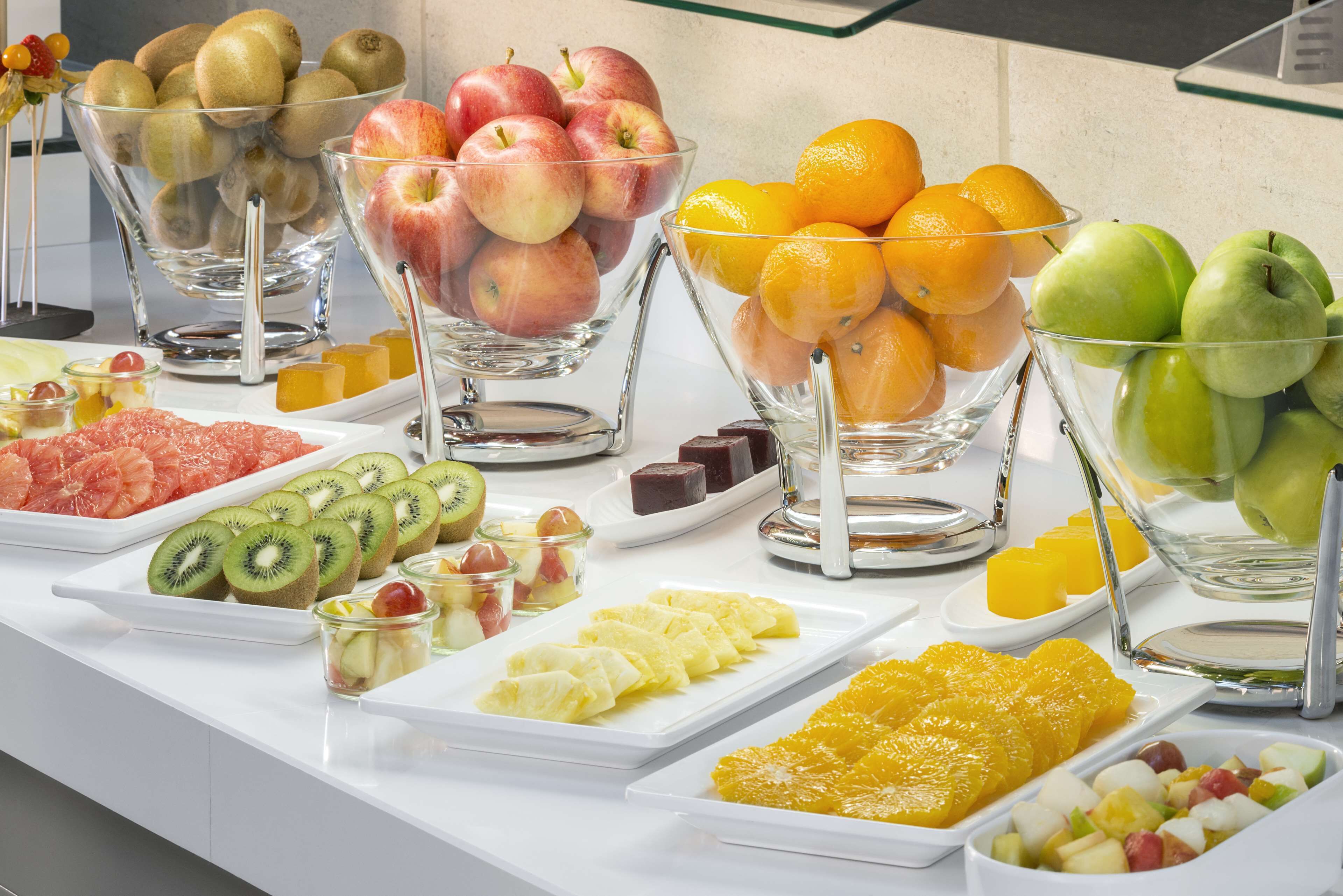 A buffet with various fruits and desserts.