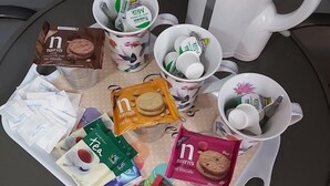 A tray with various food items and a white mug on a round table. - The Vale Hotel (Hull)