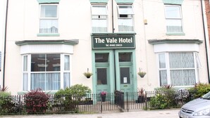 The Vale Hotel with a green front door, two windows with curtains, and a signboard. - The Vale Hotel (Hull)