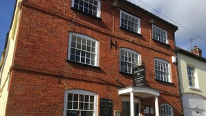 A brick building with a sign for The Silverton Inn, featuring a pub and restaurant. - The Silverton Inn - B&B (Exeter)
