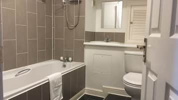 Un baño con bañera, inodoro y ducha.