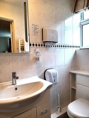A bathroom with a sink, toilet, and hand dryer. - Hunters Lodge (Southampton)
