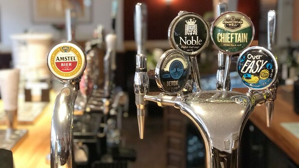 Un bar con varias griferías de cerveza, incluyendo marcas como Amstel, Noble y Franciscan Well.