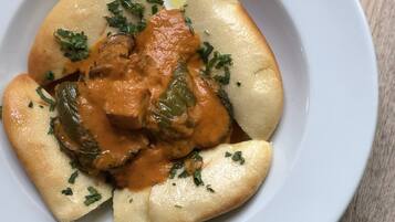 A plate of food with a creamy sauce, green vegetables, and herbs.