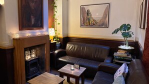 Un salón acogedor con chimenea, sofá de cuero y una mesita de centro.