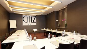 A conference room with a long table, chairs, water bottles, and a whiteboard. - Citiz Hotel (Toulouse)