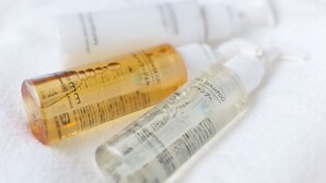 Tres botellas de productos para el cuidado del cabello sobre una superficie blanca.