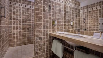 Un baño con un espejo grande, dos lavamanos y una zona de ducha.