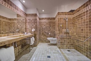 Een badkamer met betegelde vloer, wastafel, toilet en douchehoek.