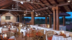 Un restaurante con vigas de madera y mesas dispuestas para comer, con vistas panorámicas.