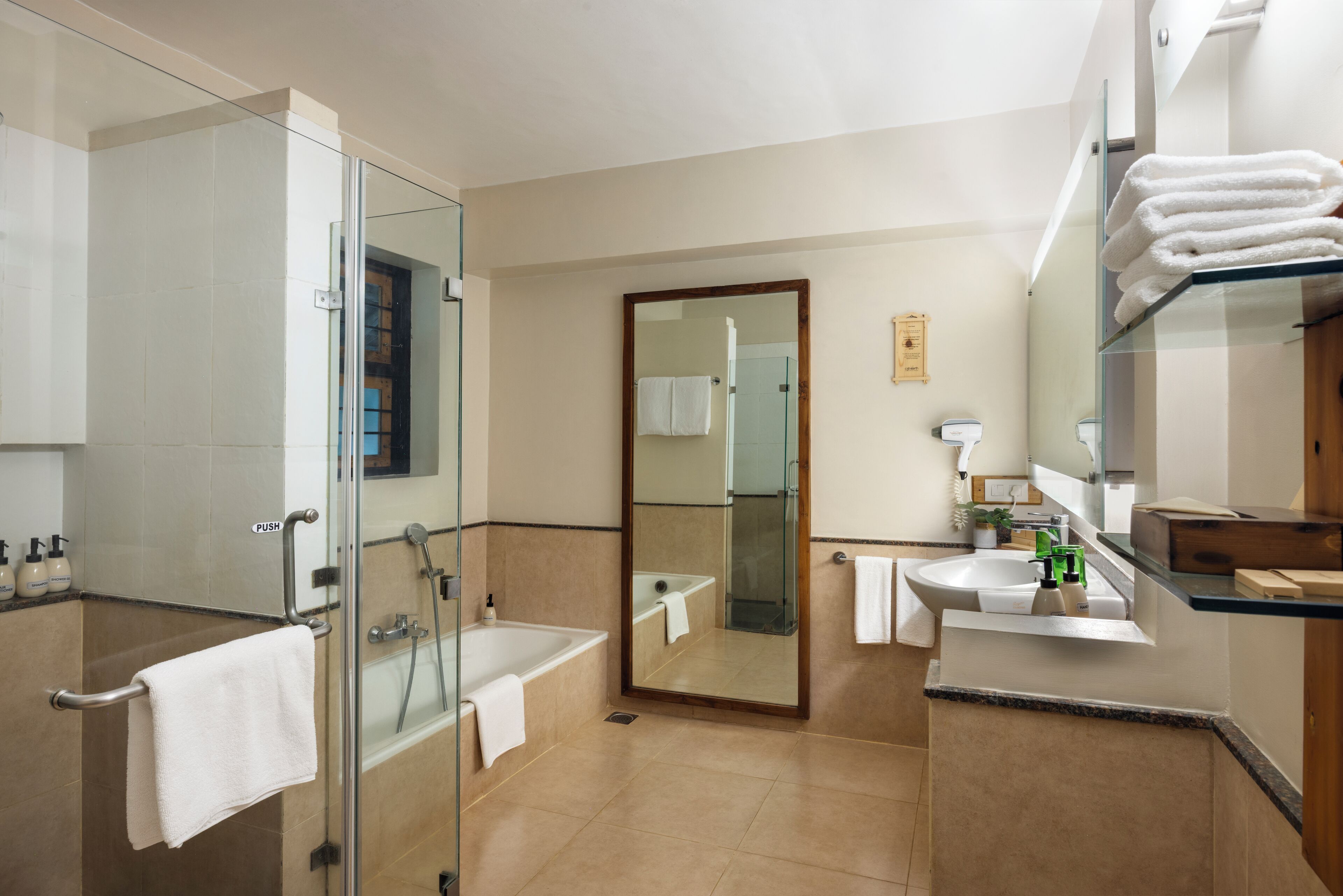 Un baño moderno con cabina de ducha de vidrio, bañera, lavabo y un espejo grande.
