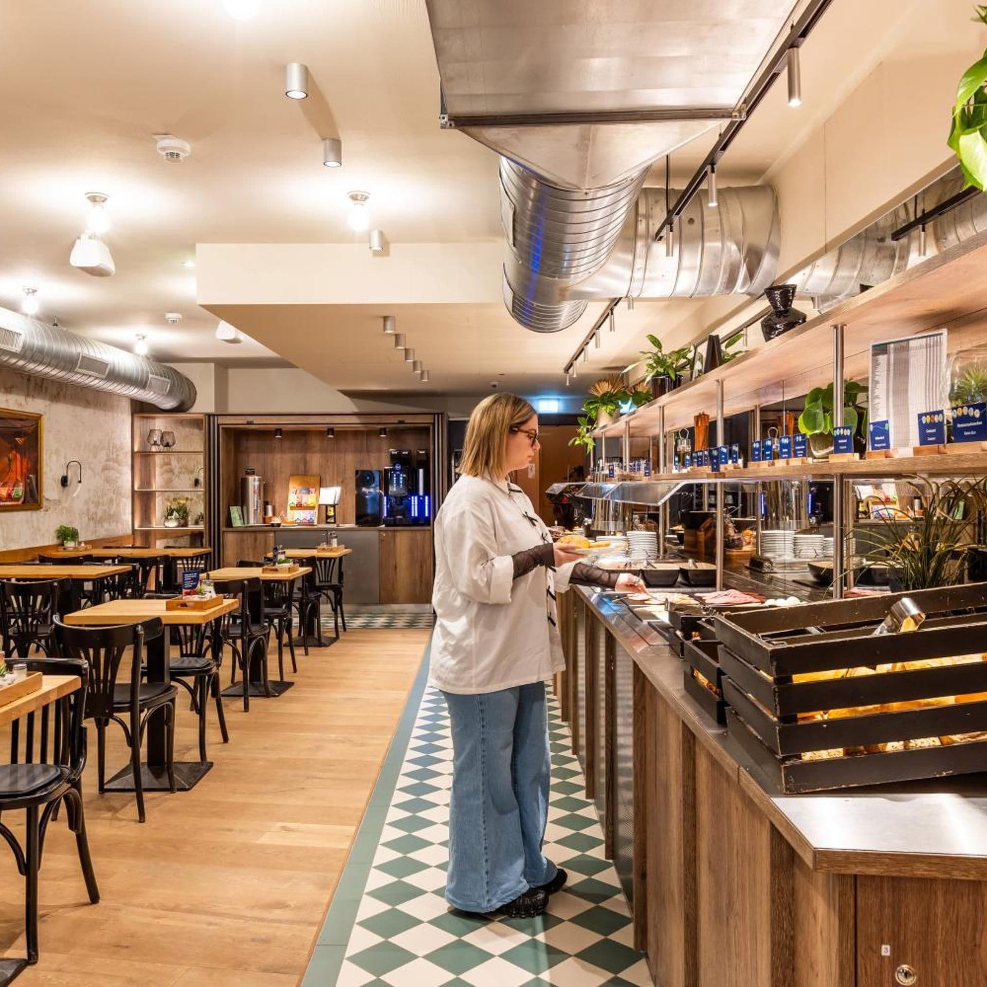 A restaurant interior with a bar area, seating, and a person serving.