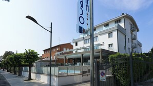 Un hotel moderno con piscina, balcones y cielo despejado.