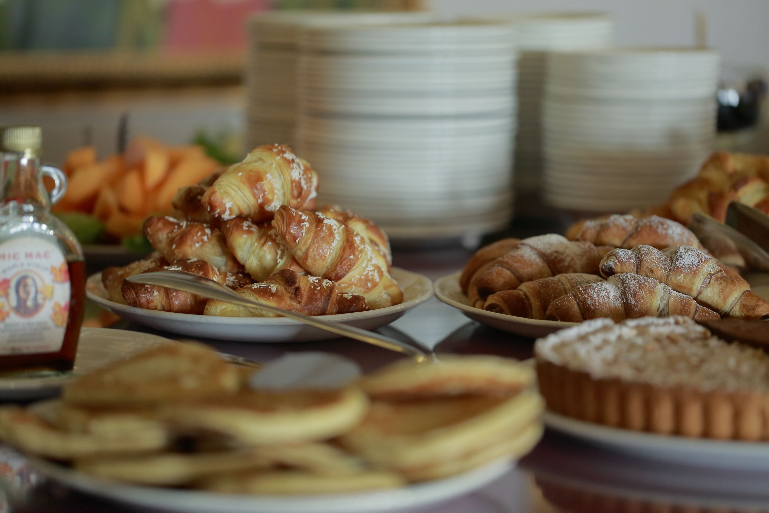 A table with various pastries and a bottle of honey mustard.