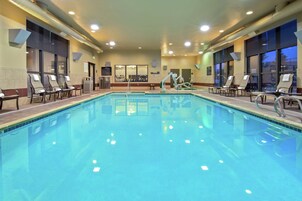 Una piscina techada, sillones reclinables de piscina