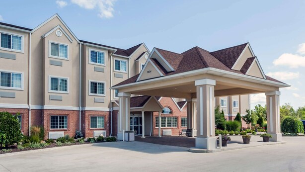 A multi-story hotel with a covered entrance and a brick facade.