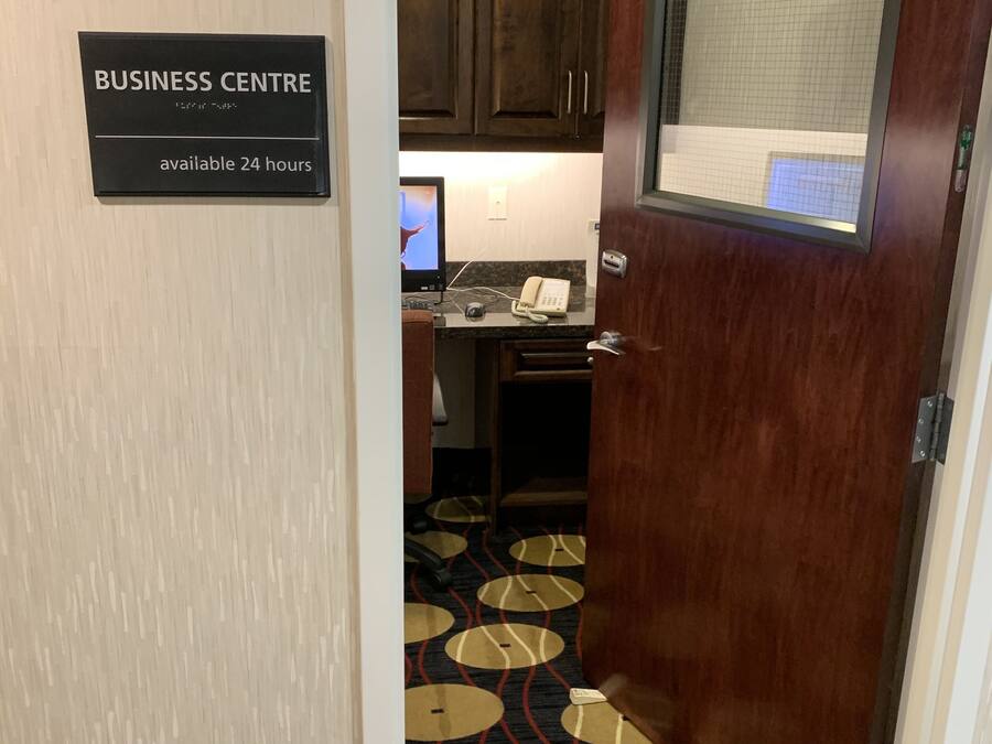 A hotel business center with a sign indicating 24-hour availability.
