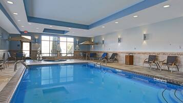 Relax by the pool surrounded by lounge chairs and umbrellas.