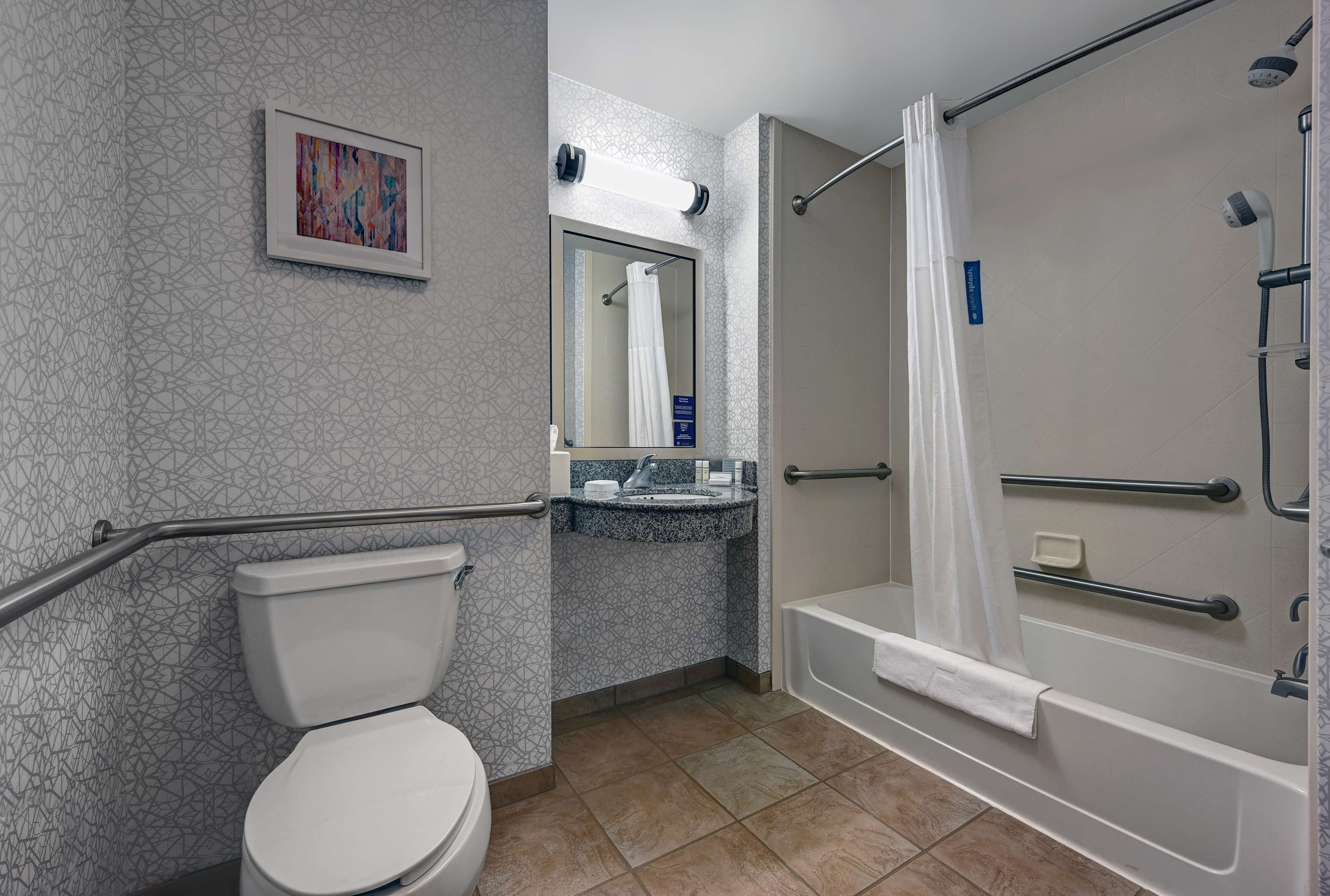 Un baño con inodoro, lavamanos, espejo, ducha y bañera.