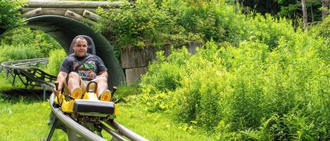 A person seated on a yellow and black roller coaster track.