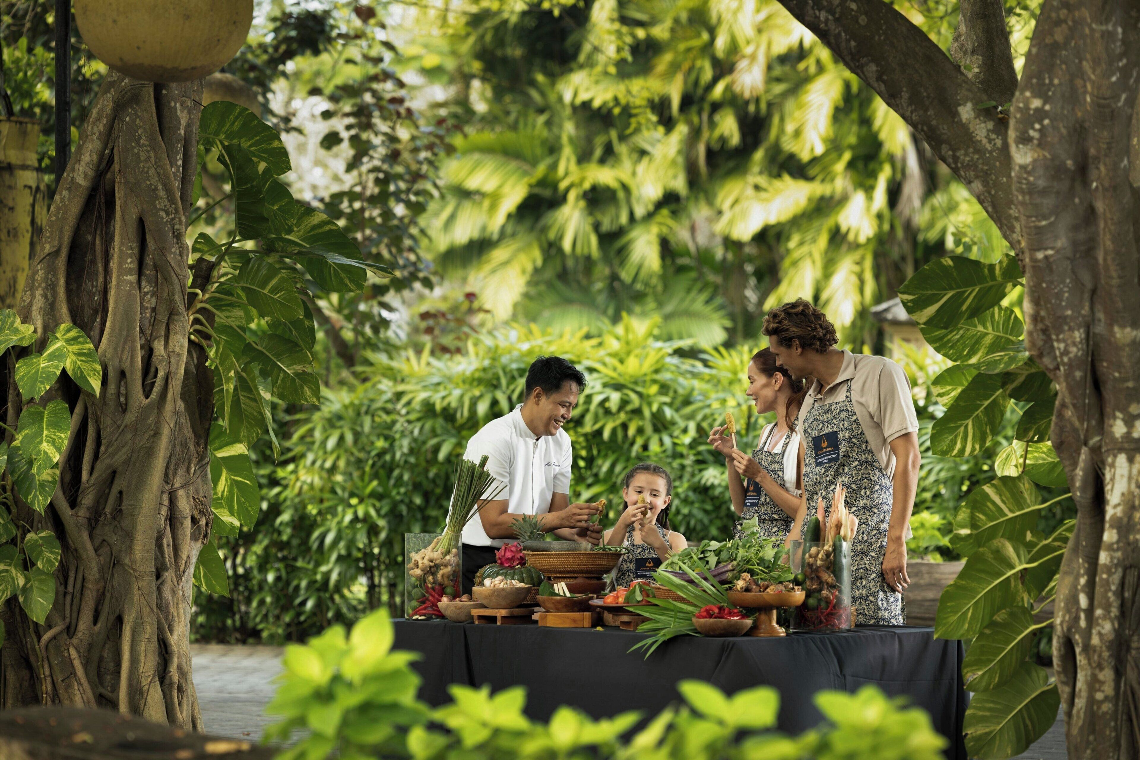 An outdoor dining area with a table set for a meal, surrounded by lush greenery and trees.
