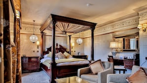 A four-poster bed with a canopy, a sitting area with a coffee table, and a desk with a lamp. - Royal Oak Hotel (Betws-Y-Coed)