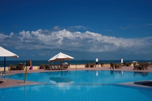A pool area with lounge chairs and umbrellas, overlooking the ocean. - Retac El Arish (Al Arish)