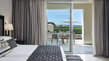 Une chambre d’hôtel comprenant un lit, une table de chevet, une lampe et une vue sur un espace extérieur aménagé avec des parasols.